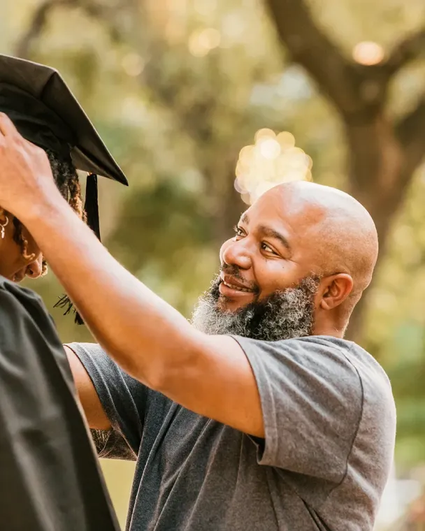 dad helping son with graduation cap